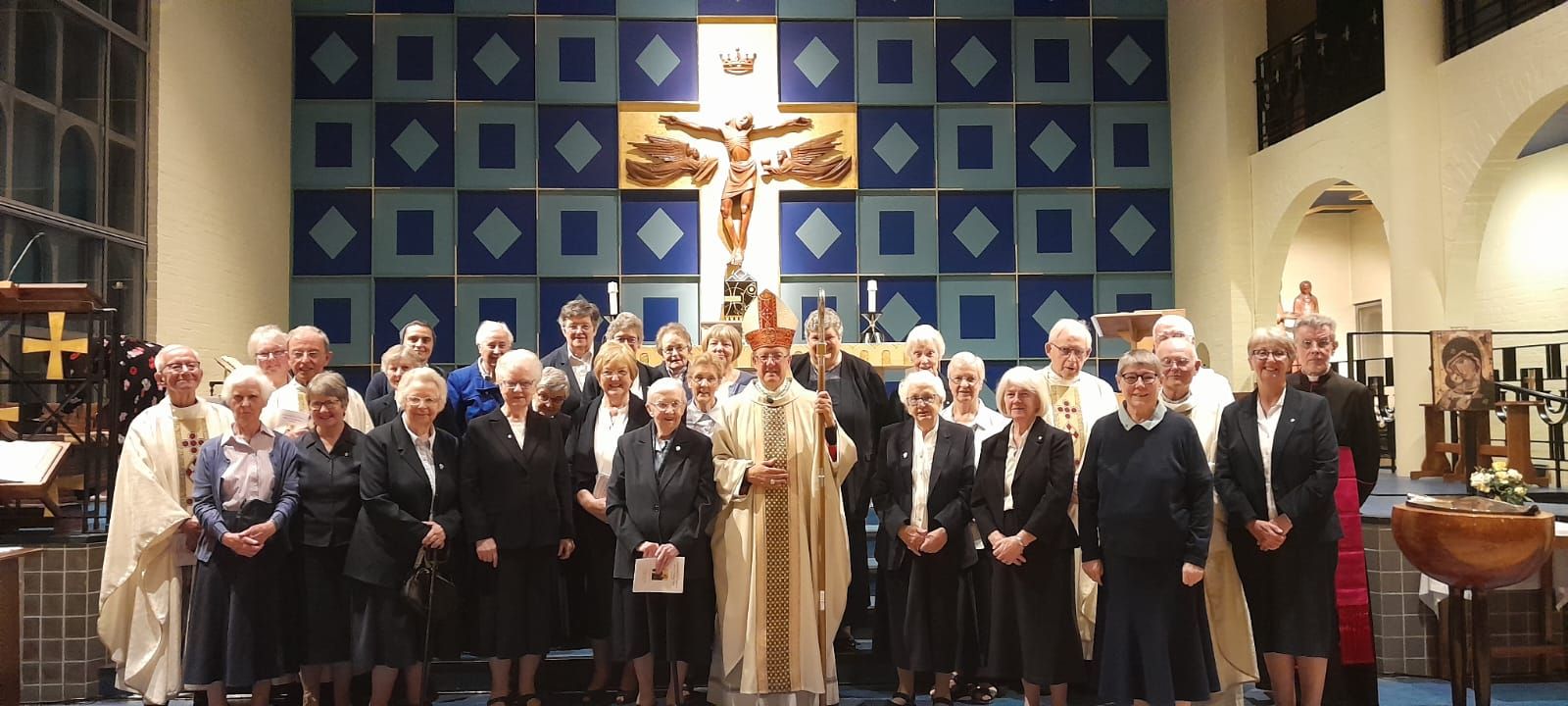 A group of people standing in front of a cross in a church