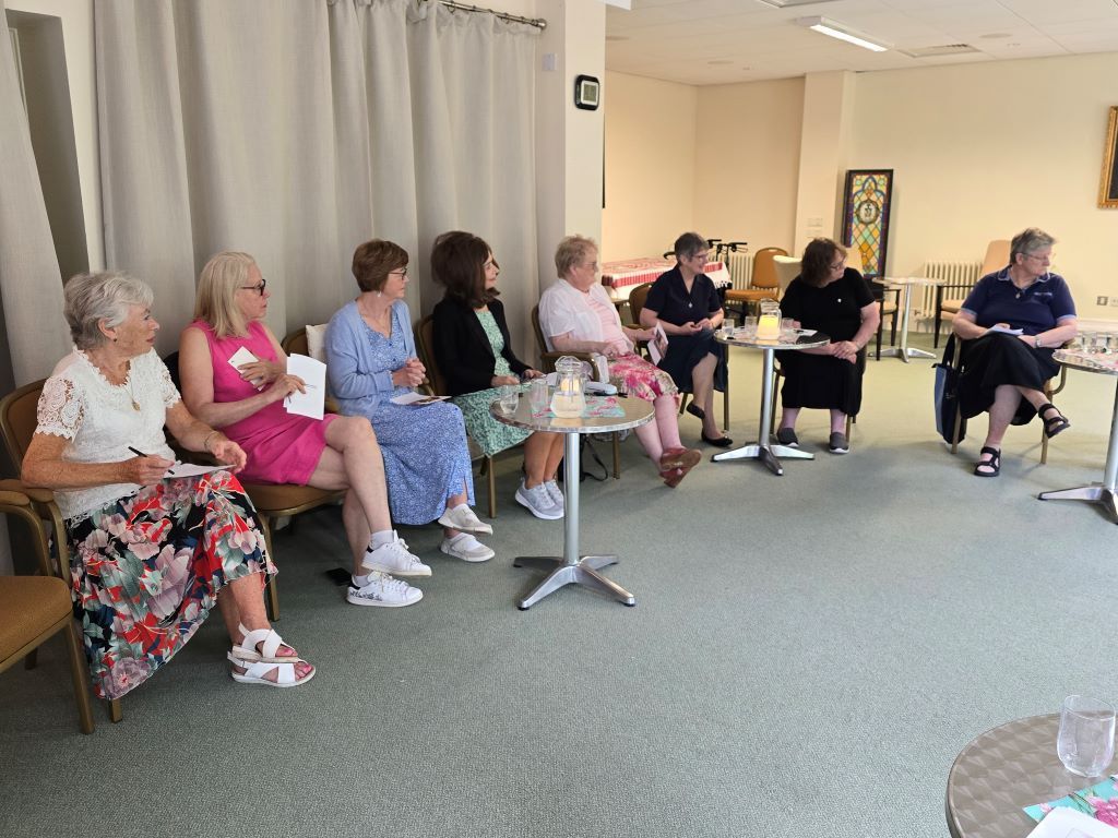A group of people are sitting around tables in a room.