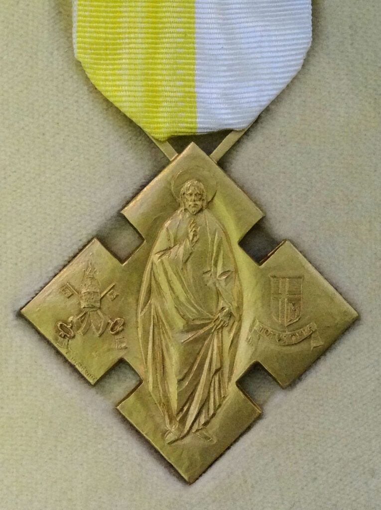 A gold medal with a picture of jesus on it