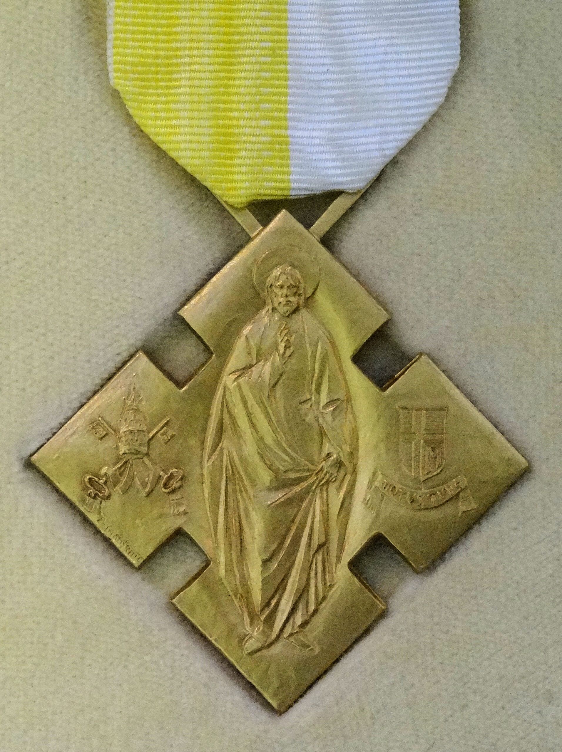 A gold medal with a picture of jesus on it