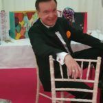 A man in a tuxedo is sitting in a chair.