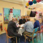 A group of people are sitting around a table in a room.