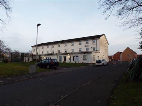 A large white building with cars parked in front of it.