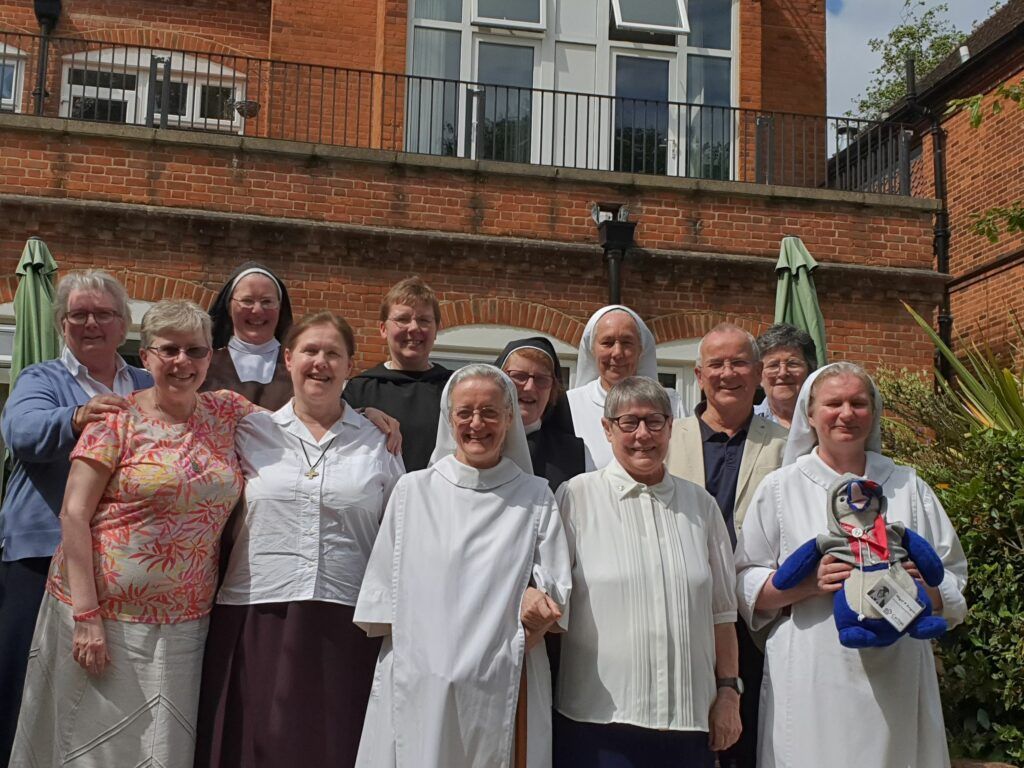 A group of people posing for a picture in front of a brick building