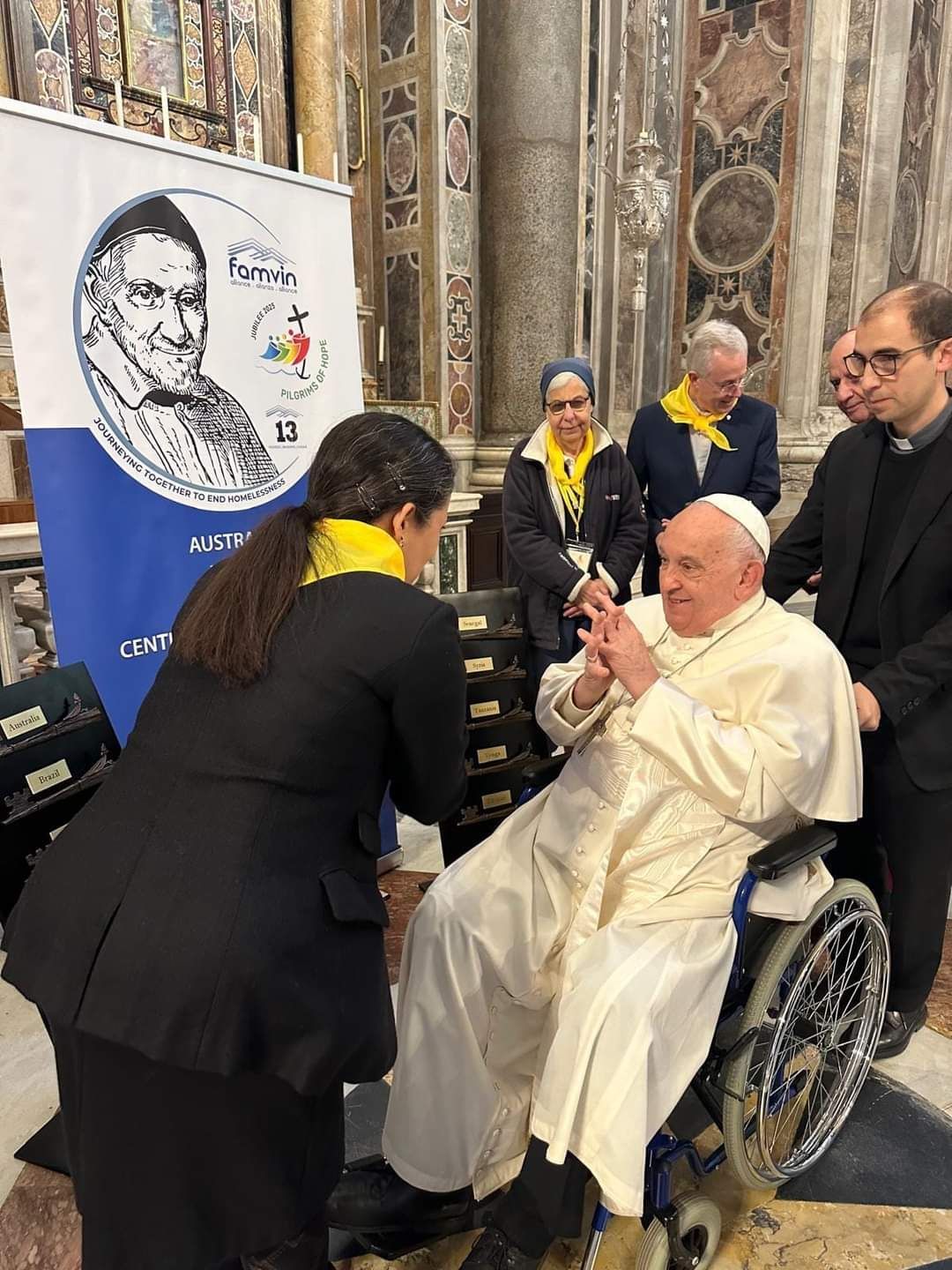 A man in a wheelchair is being helped by a woman in a church.