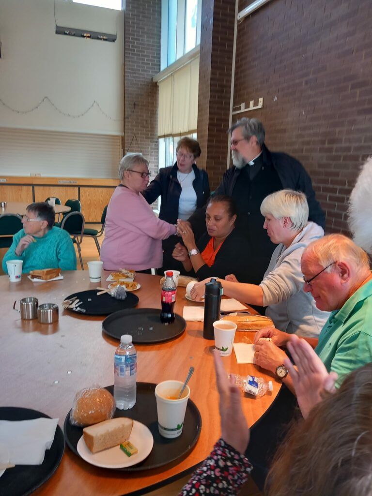 A group of people are sitting around a table eating food.