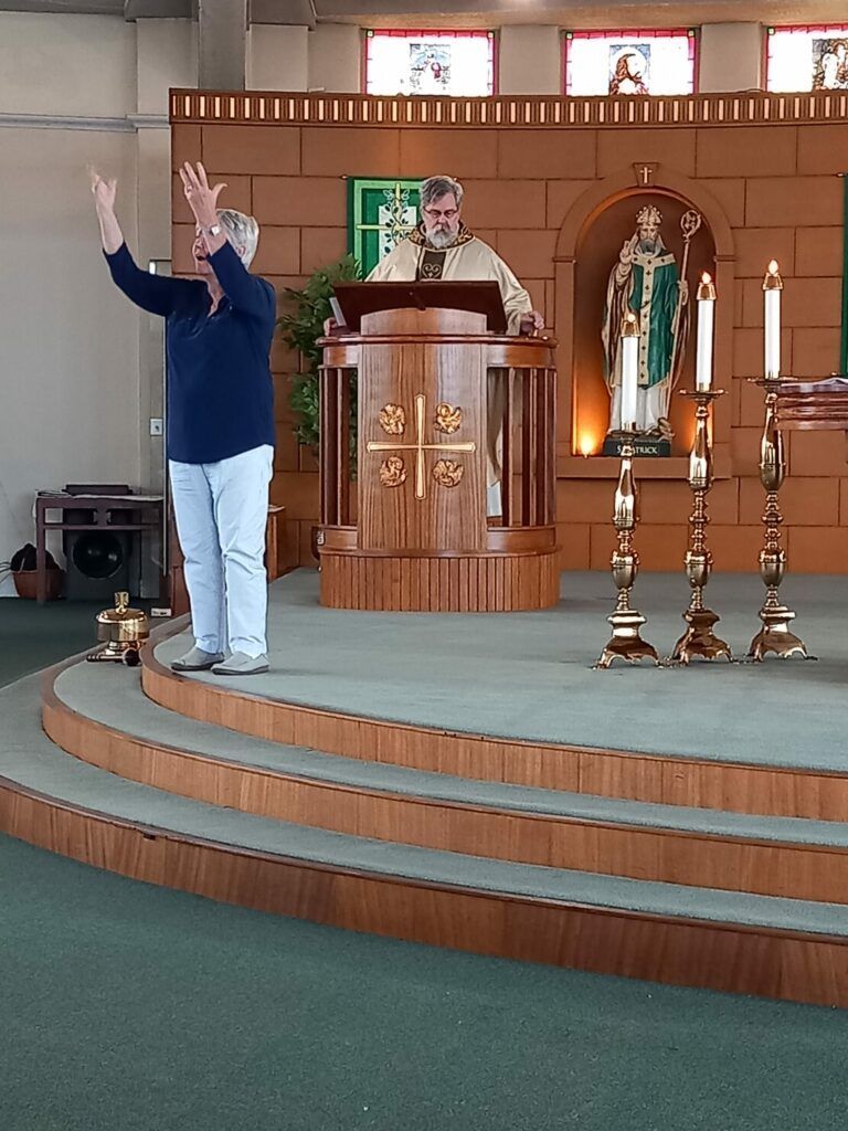 A man stands on a stage with his hands in the air