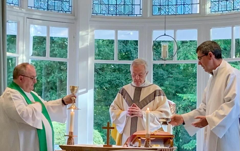 A group of priests are standing around a table in a church.