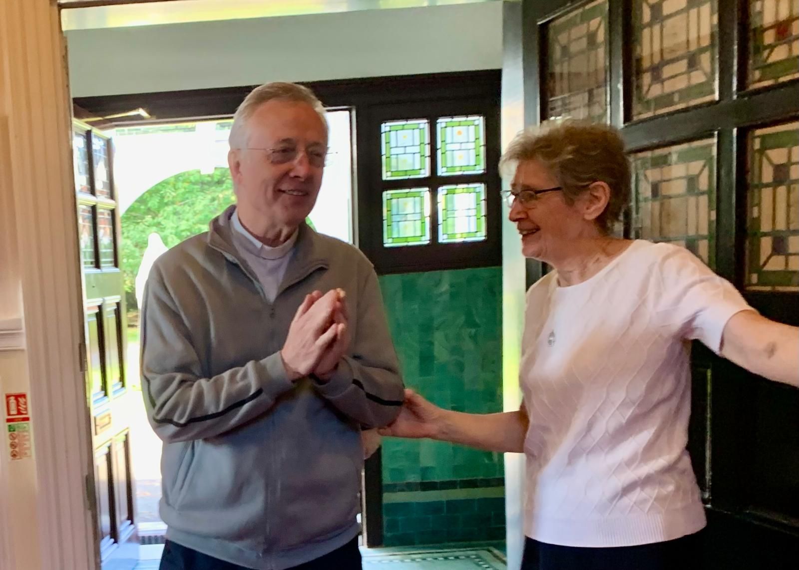 A man and a woman are standing next to each other in front of a door.