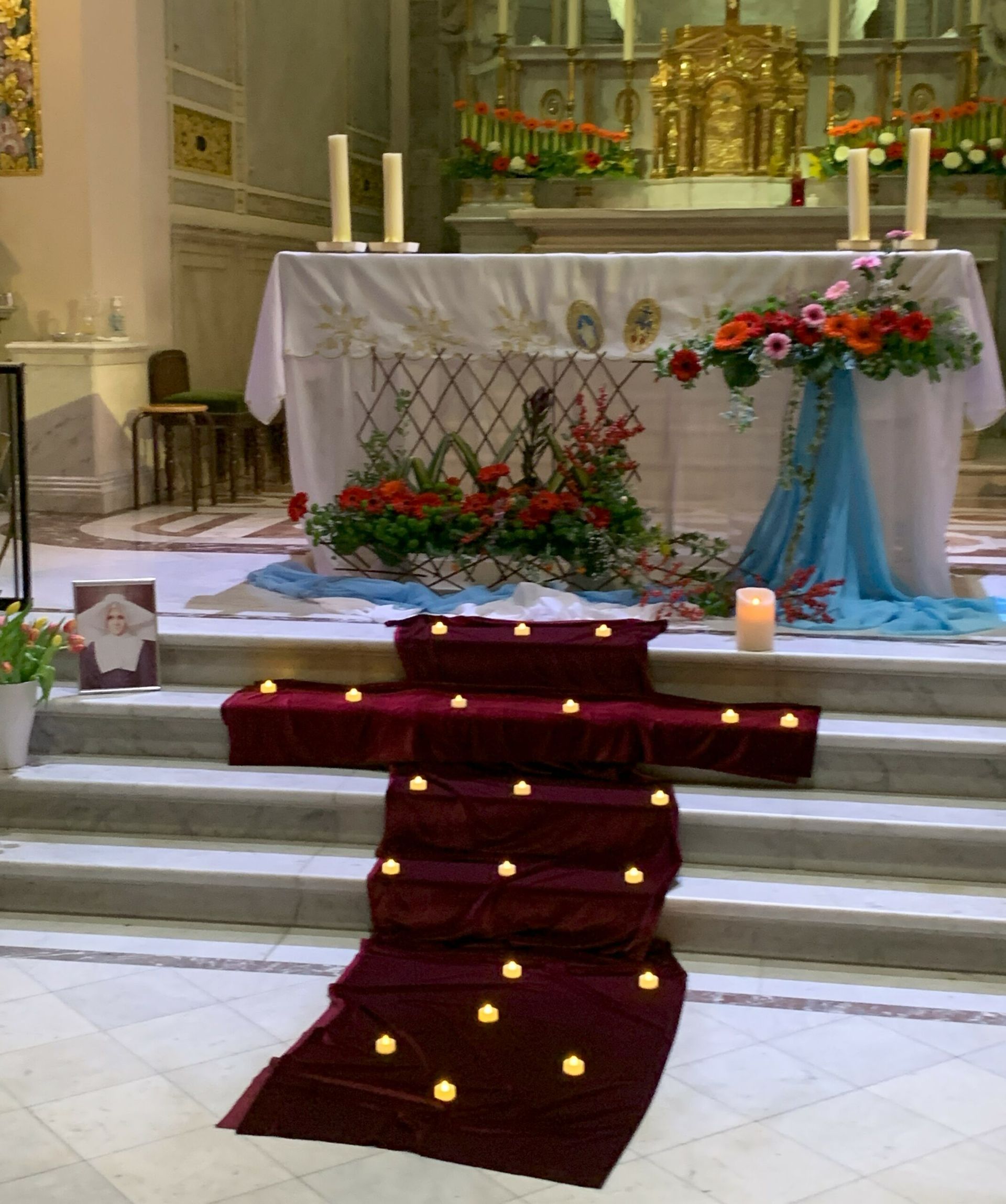 A church altar with candles and flowers on it