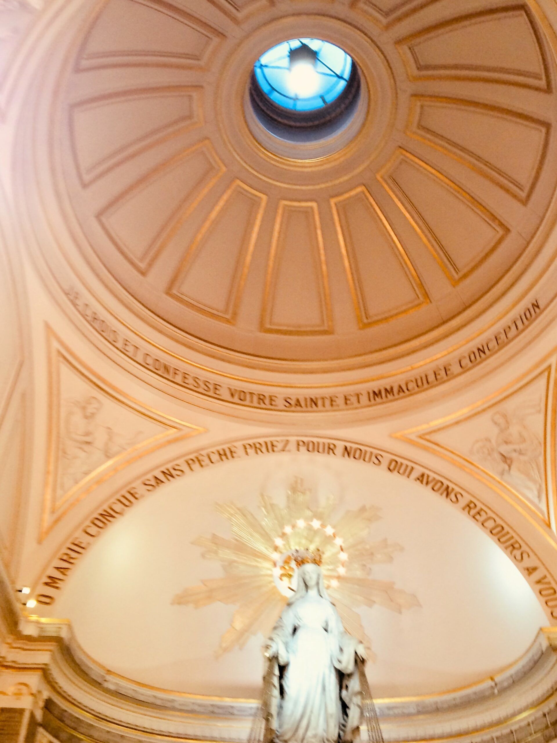 A dome in a church with a statue in front of it