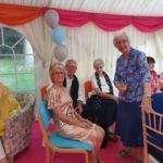 A group of people are sitting in chairs in a tent.