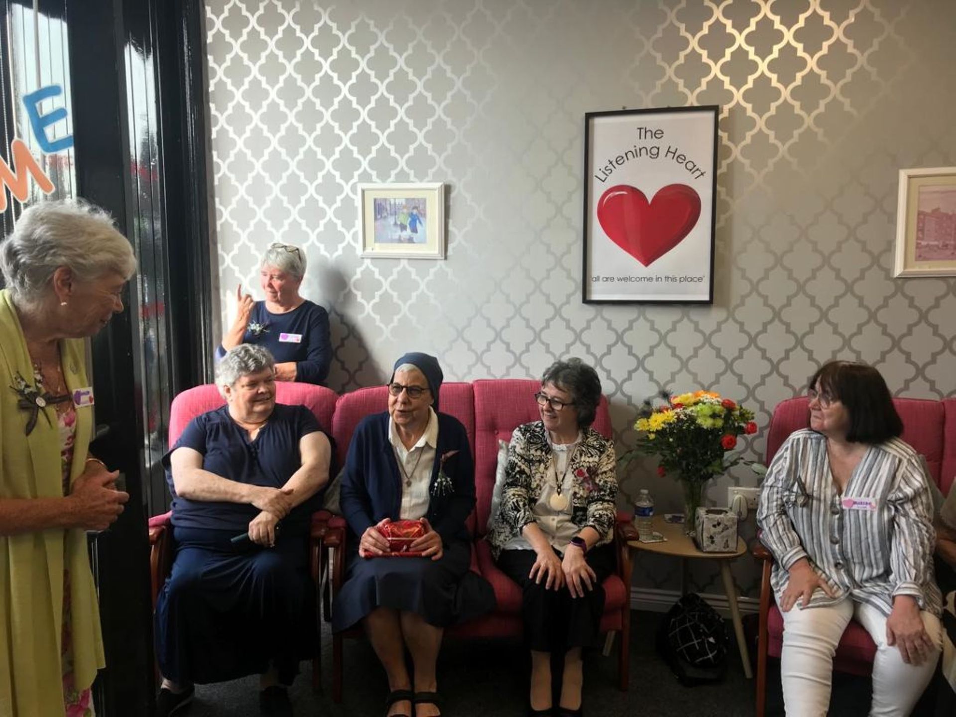 A group of women are sitting in chairs in a waiting room.