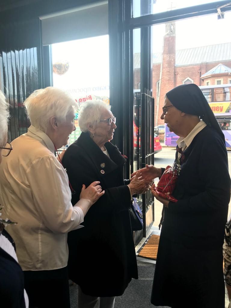 A nun is talking to a group of older women