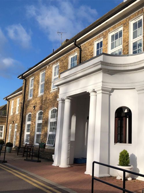 a large brick building with a white porch and columns