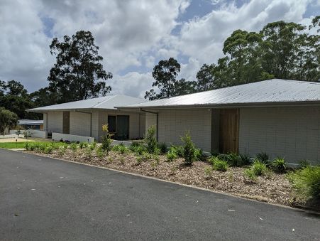 A row of white houses with trees in the background