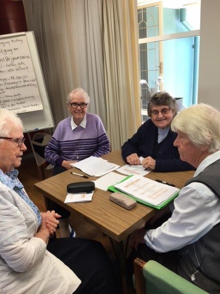 A group of people are sitting around a table with papers on it