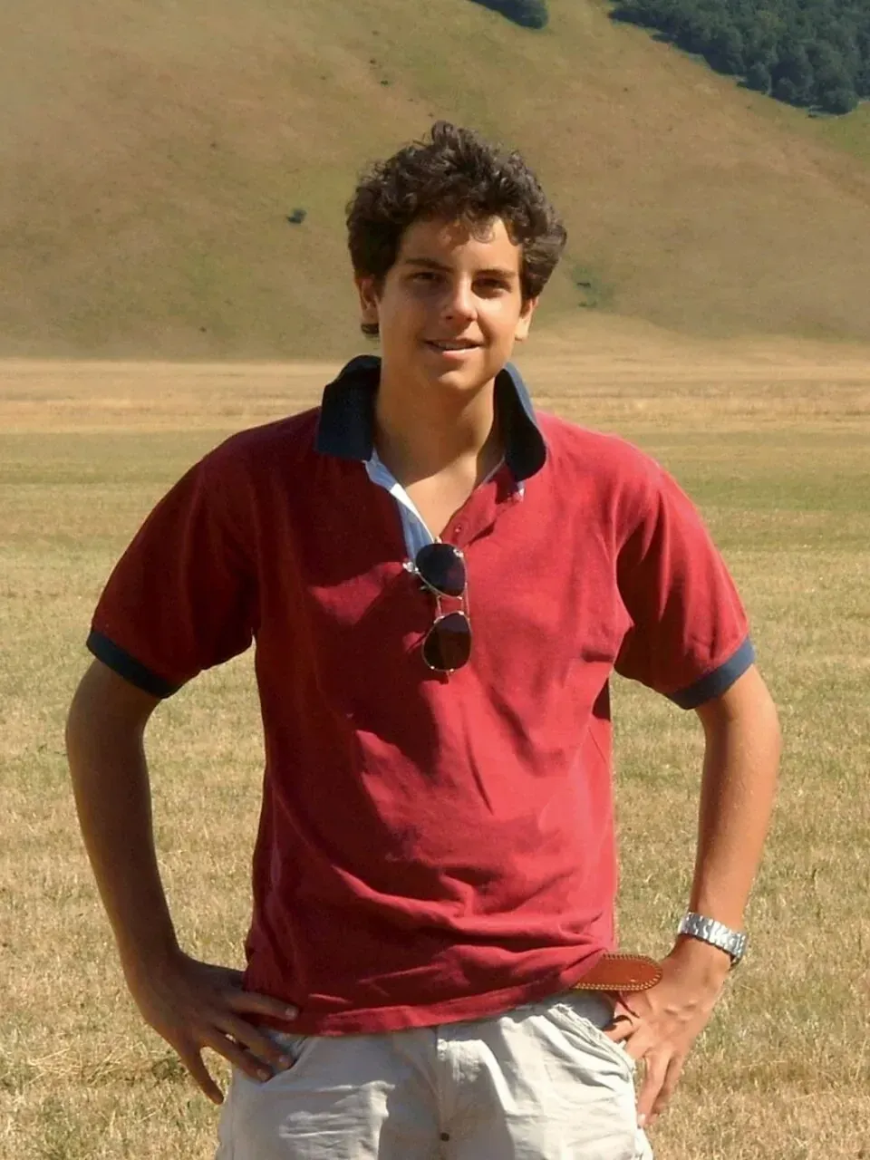 Bl Carlo Acutis standing in a field with his hands on his hips