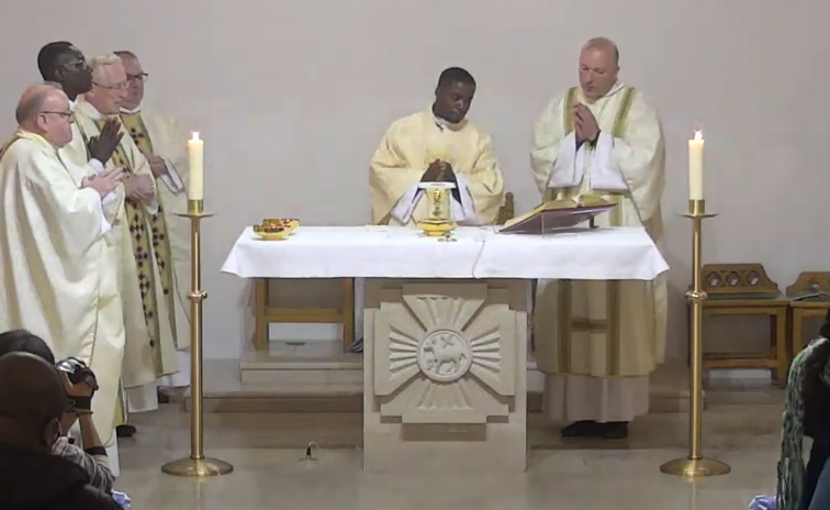A group of priests are standing around an altar in a church.