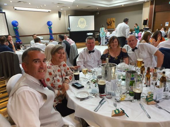 A group of people are sitting at tables at a party.