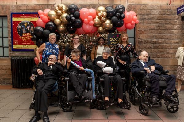 A group of people in wheelchairs are posing for a picture.