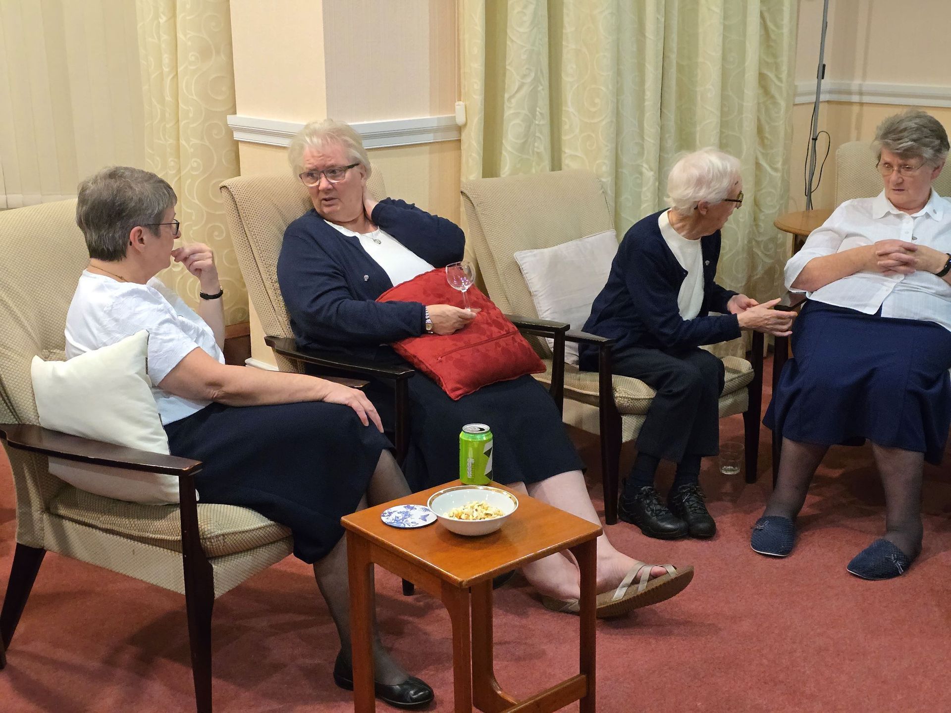 A group of women are sitting in chairs in a room