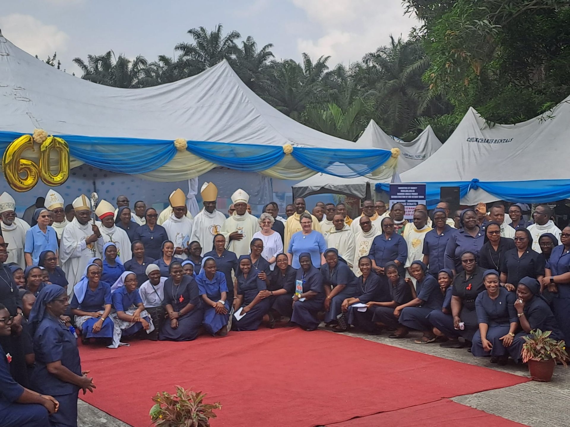 A large group of people are posing for a picture in front of a tent.