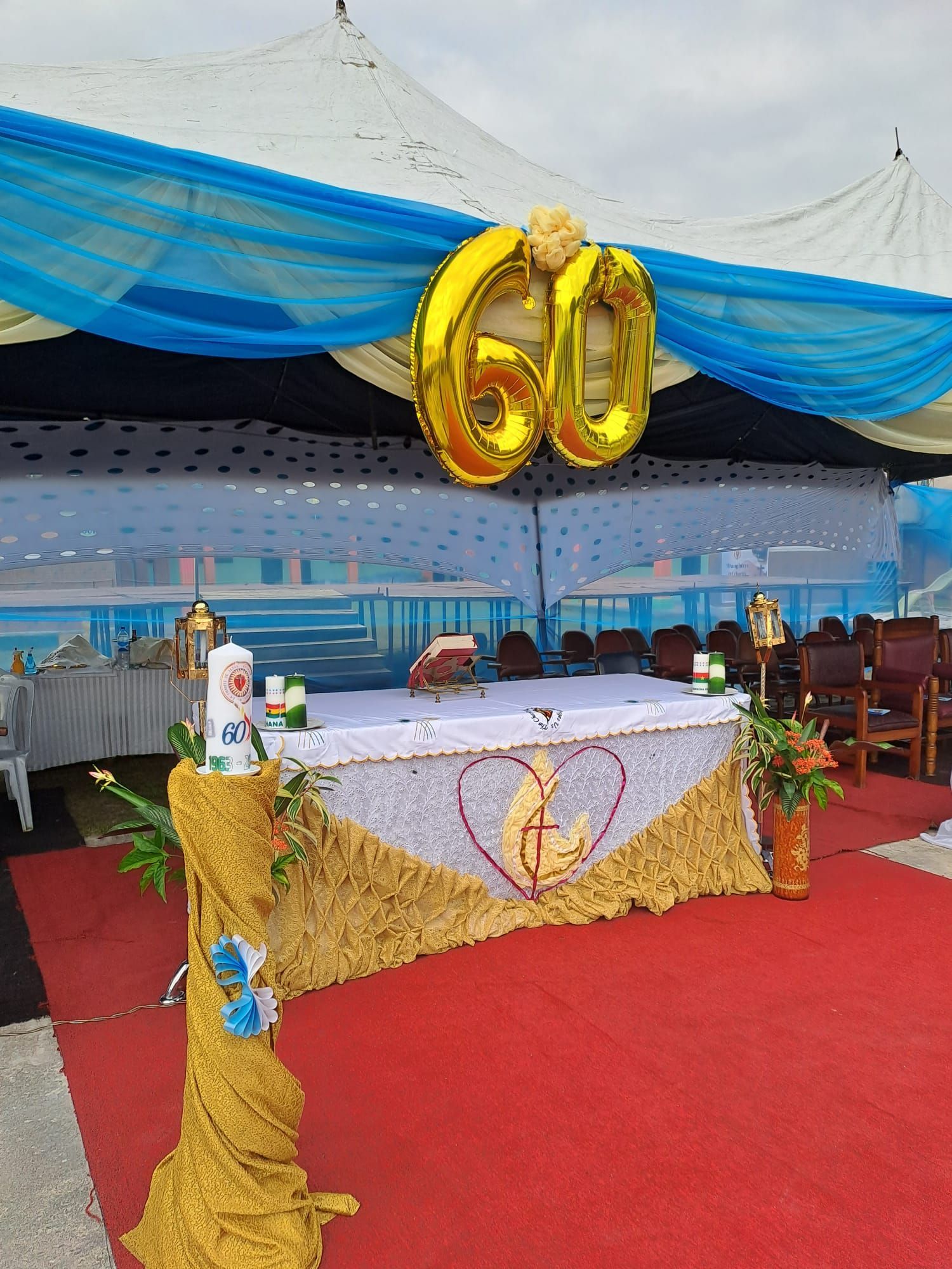 A table is decorated with balloons and candles for a 60th anniversary.