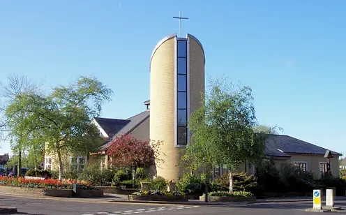 A large brick building with a cross on top of it