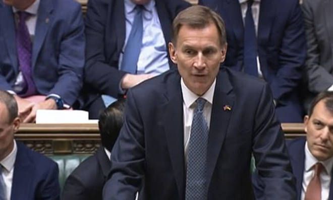 A man in a suit and tie is giving a speech in front of a crowd.