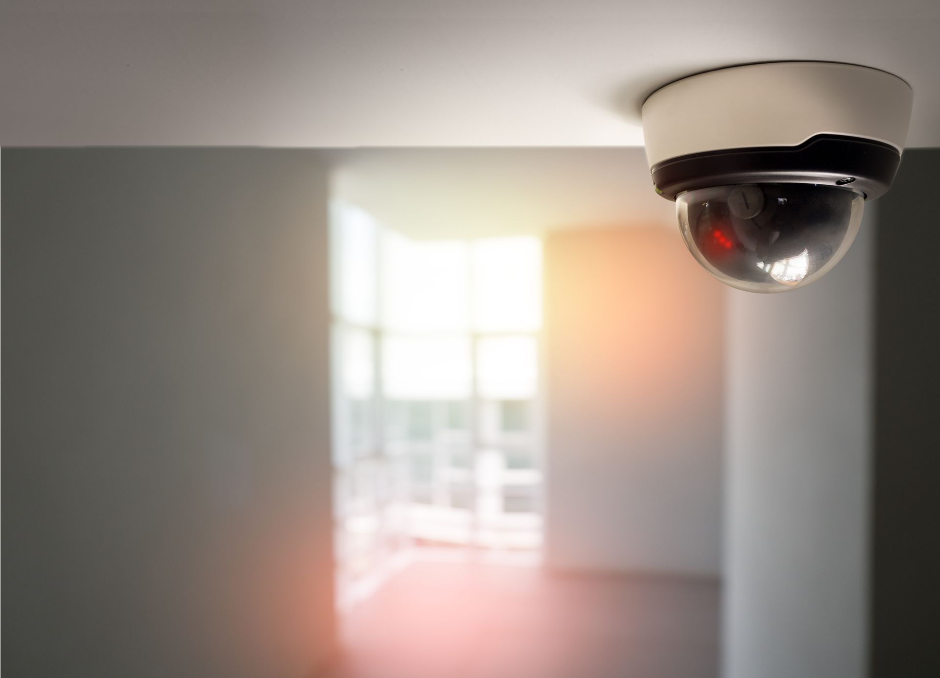 Ceiling-mounted dome security camera monitoring an indoor space for safety and surveillance.