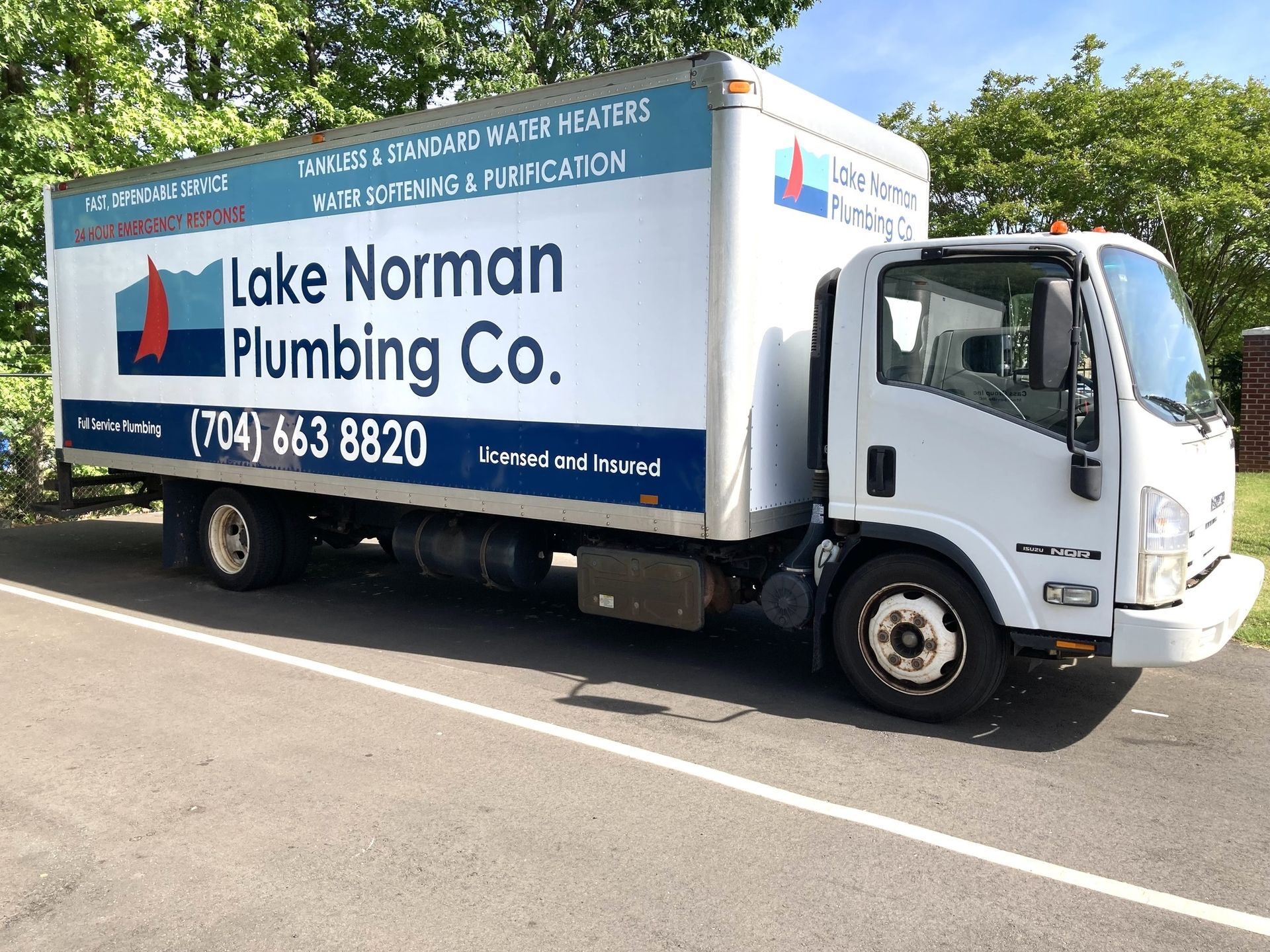 Lake Norman Plumbing Co. box truck parked on a street, with blue and white company branding.