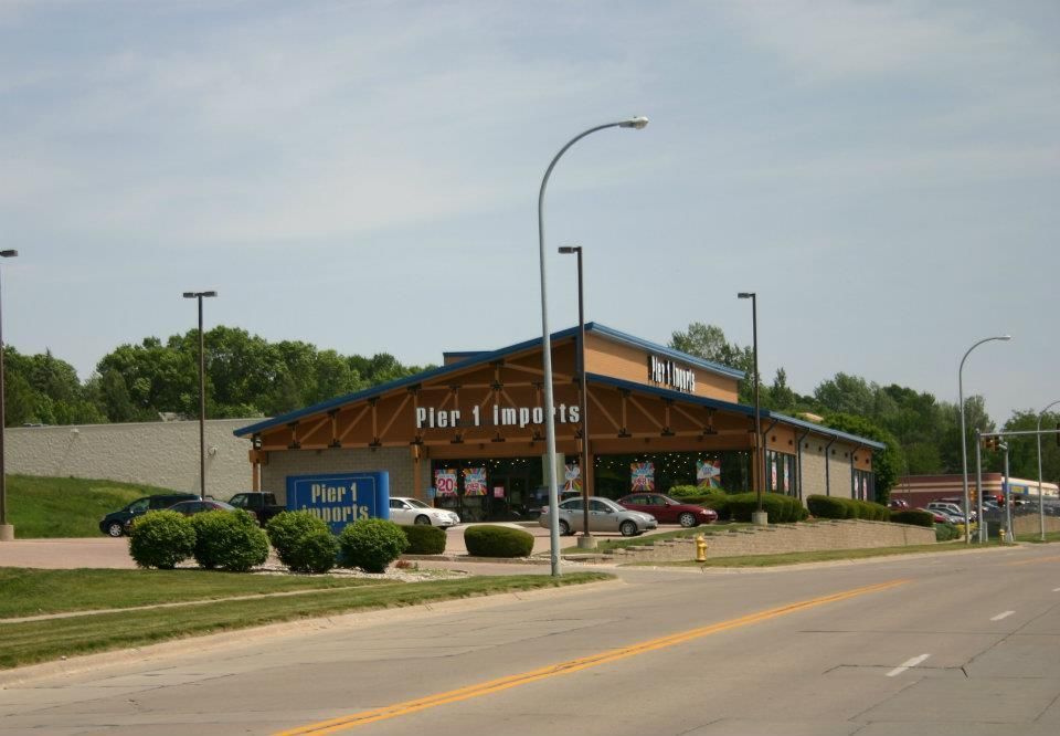 Pior Imports storefront by a road, with cars, streetlights, and a partly cloudy sky
