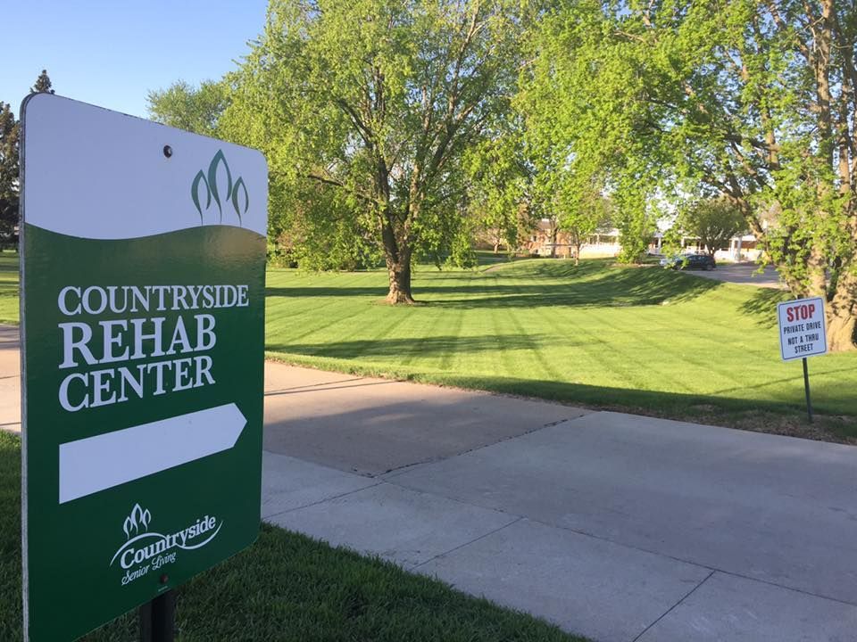 Countryside Rehab Center sign beside a sidewalk and grassy lawn on a sunny day