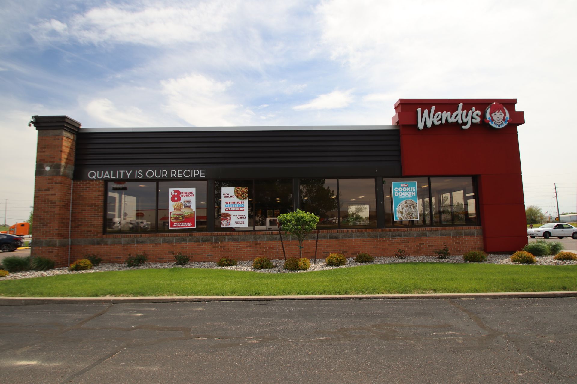 Wendy’s restaurant exterior with red sign, brick facade, and drive-thru window
