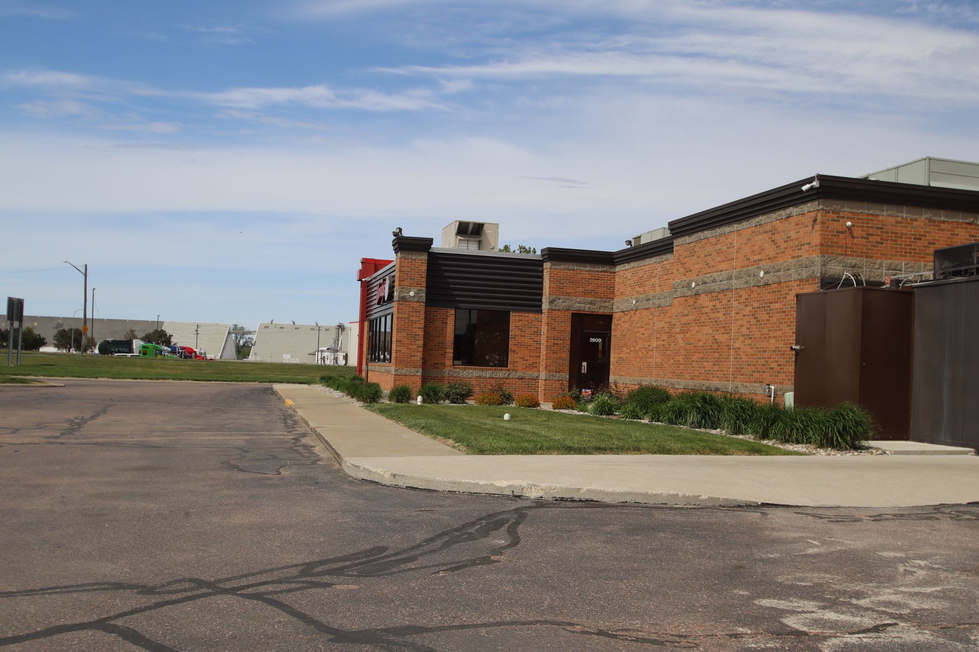 Brick building along a paved road under a cloudy sky