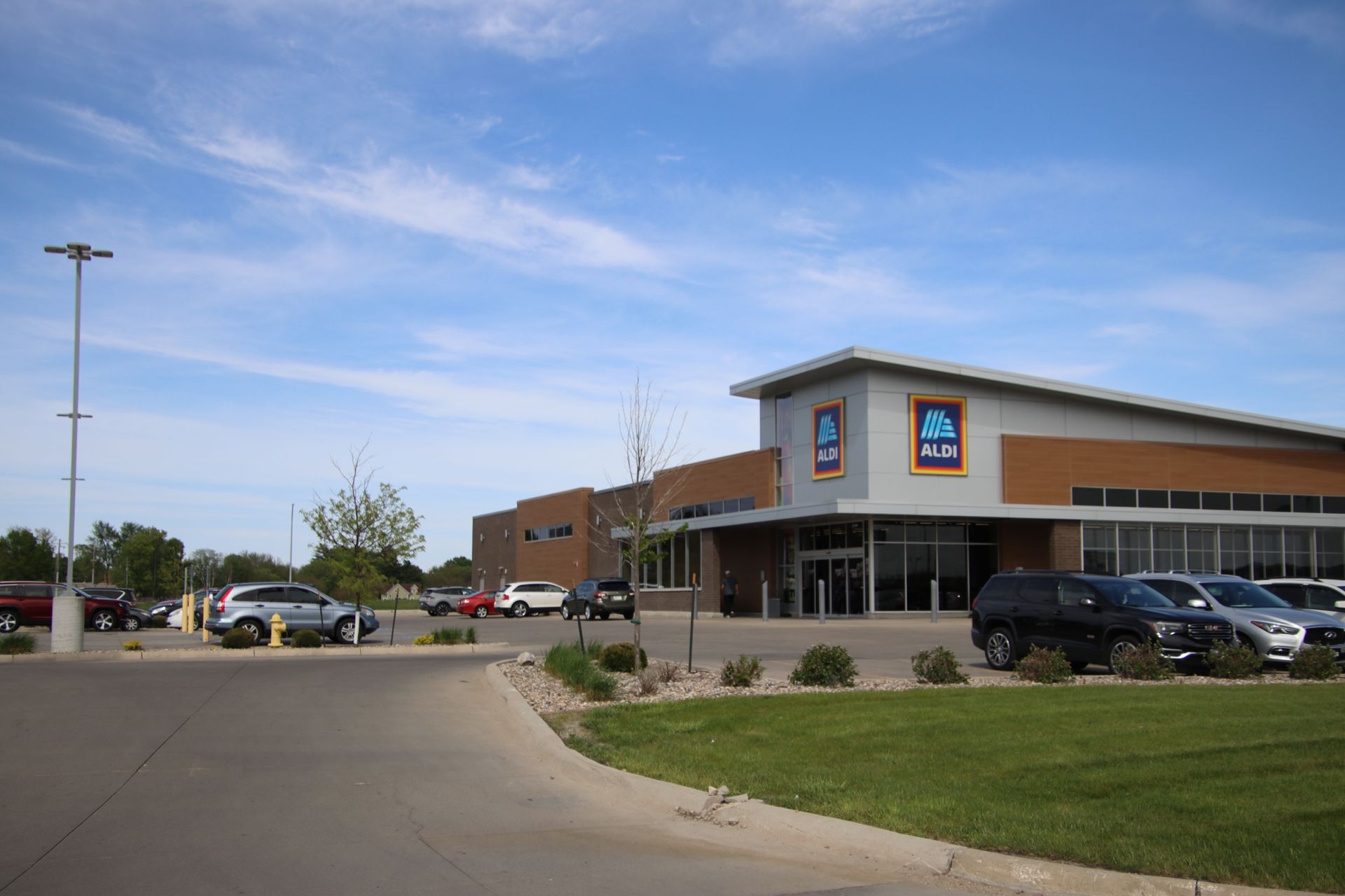 Aldi grocery store exterior with parked cars and a clear blue sky