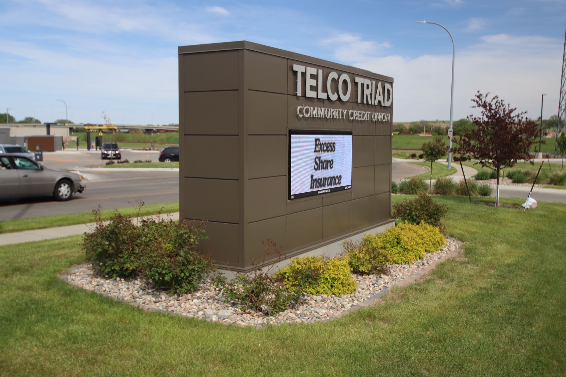 TELCO TRIAD business sign beside a road, with landscaping and grass in front.