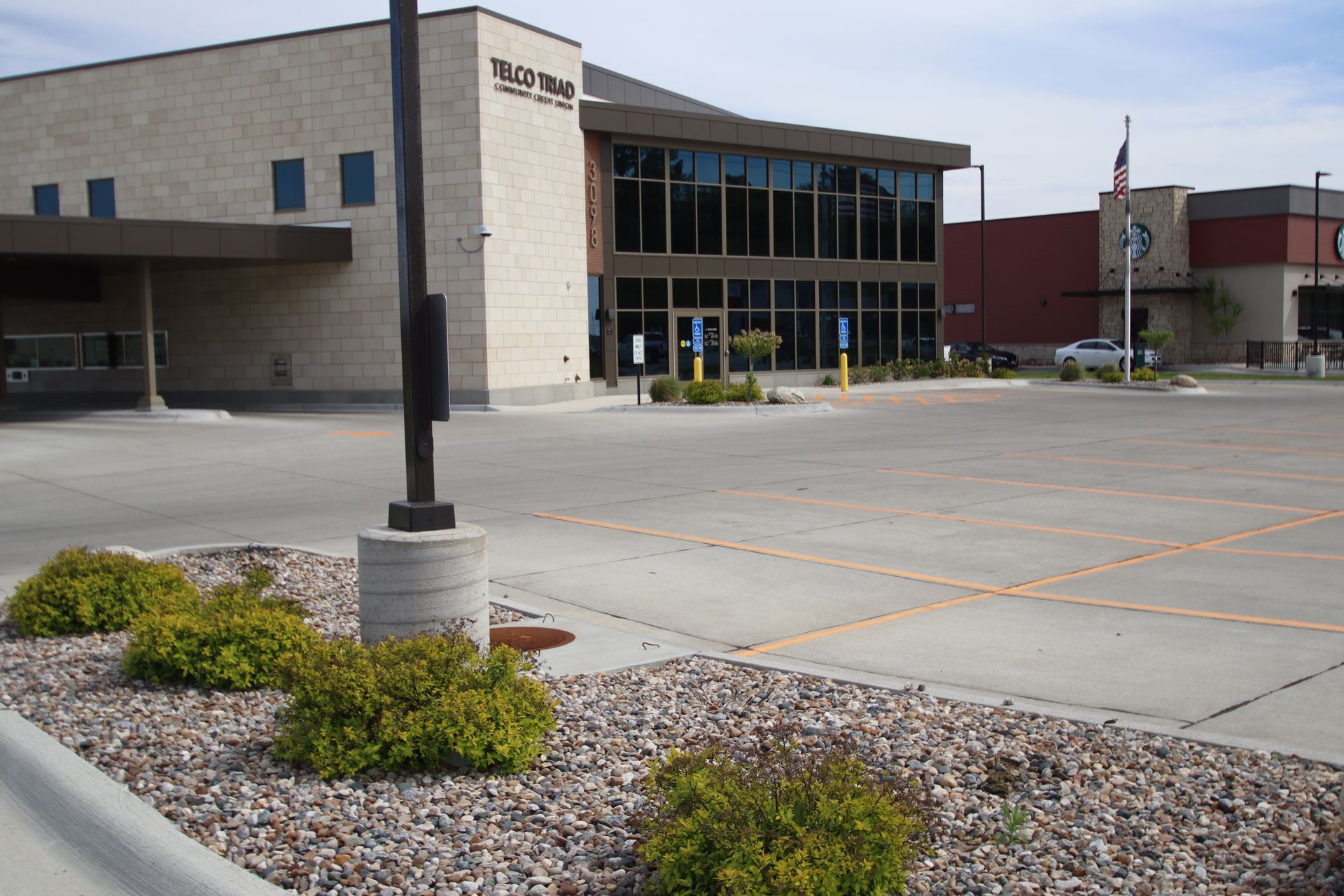 Modern school building with glass entrance and empty parking lot on a sunny day