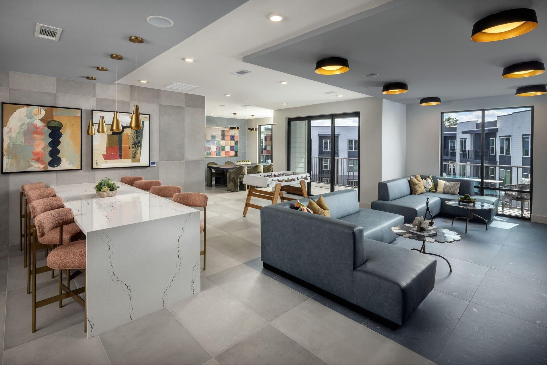 Modern coworking lounge with sofas, bar stools, tables, and large windows