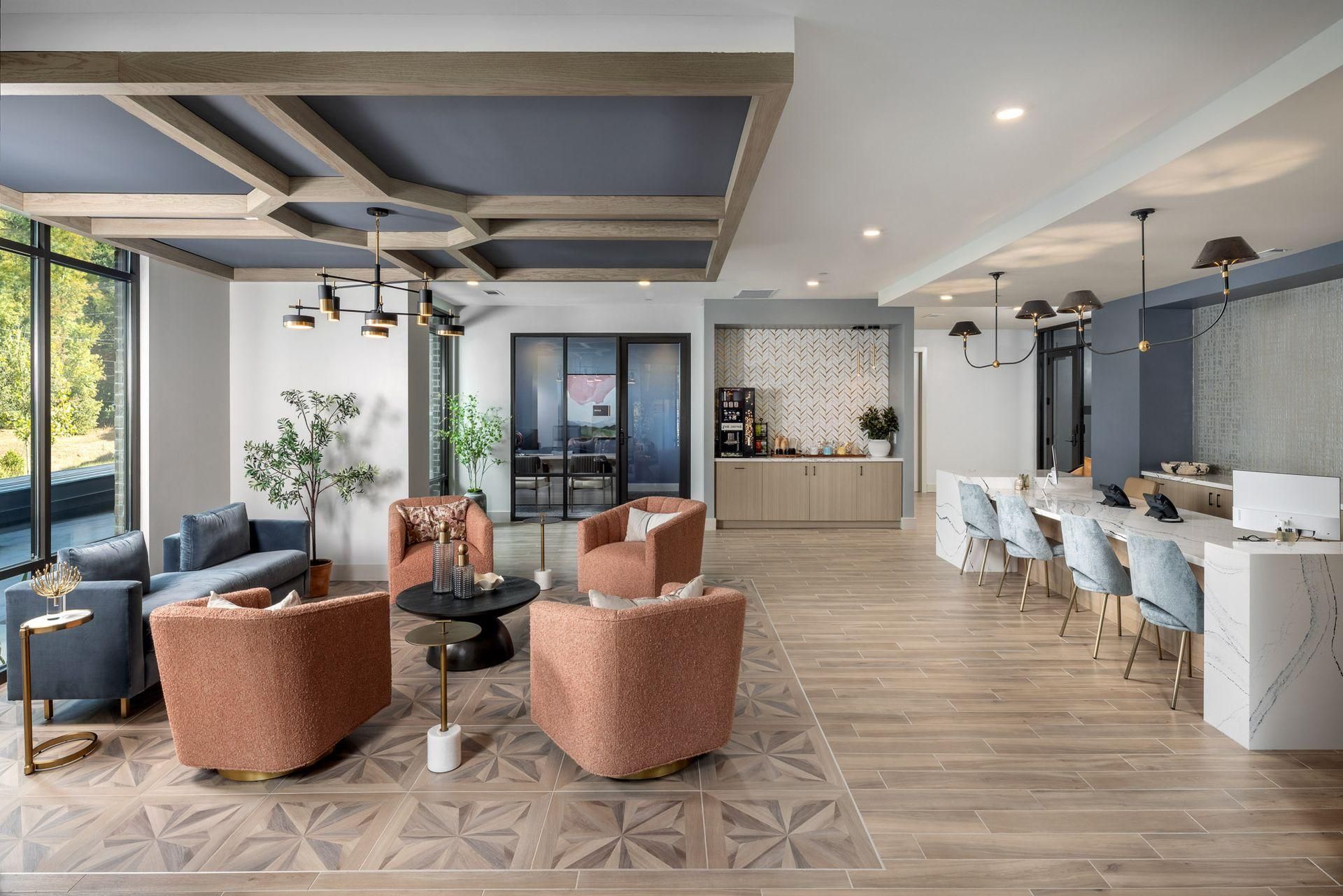 Modern open lounge with patterned chairs, blue sofa, dining tables, and large windows in a bright interior