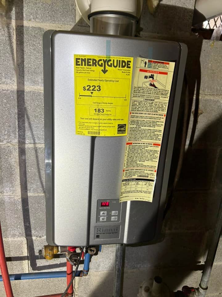 A wall-mounted Rinnai tankless water heater with yellow EnergyGuide and instruction labels on a grey concrete block wall.