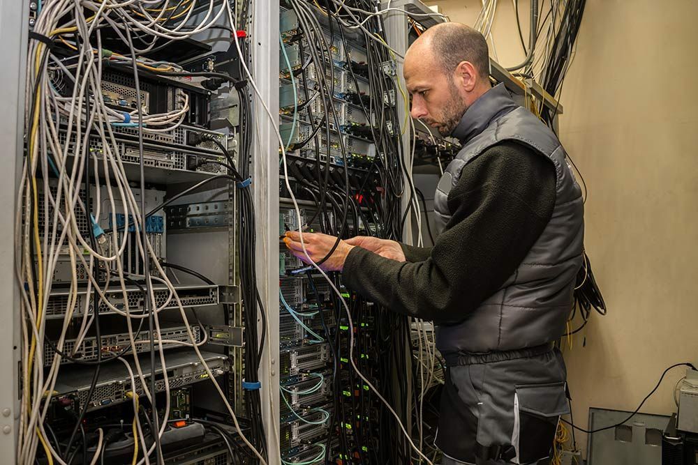 A Man is Working on a Server in a Server Room — Frontier Connect in Plainland, QLD