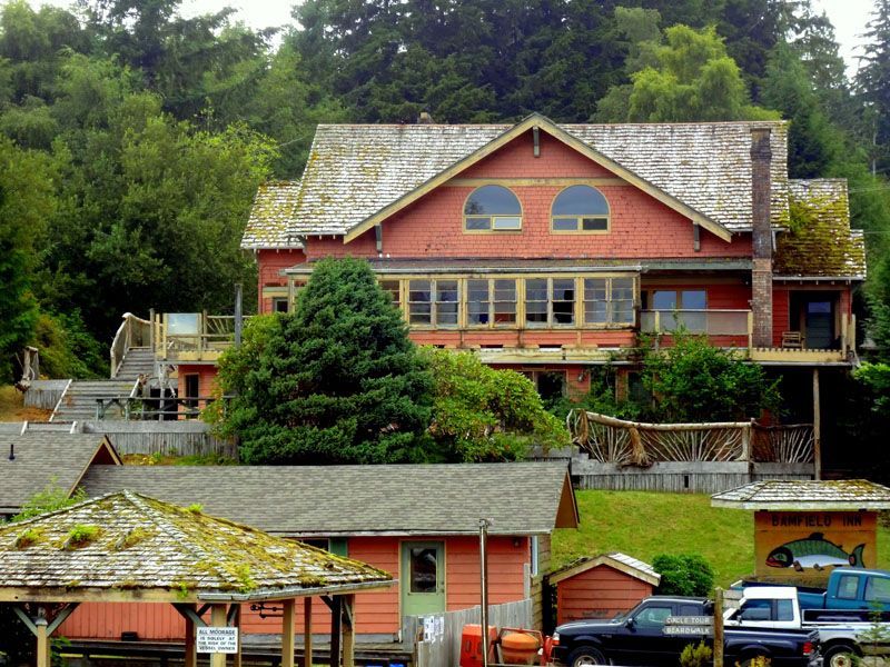 A large house sits on top of a hill surrounded by trees