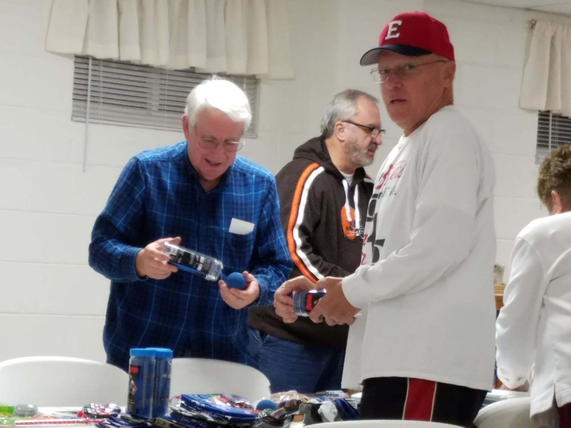 People serving drinks at a table during an indoor gathering