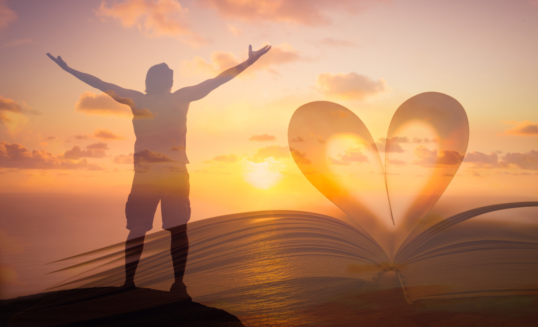 Silhouette of a person with raised arms at sunset beside a heart shape formed by pages on a book