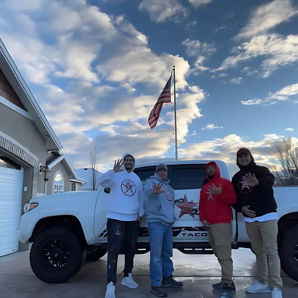 A group of people standing in front of a taco truck