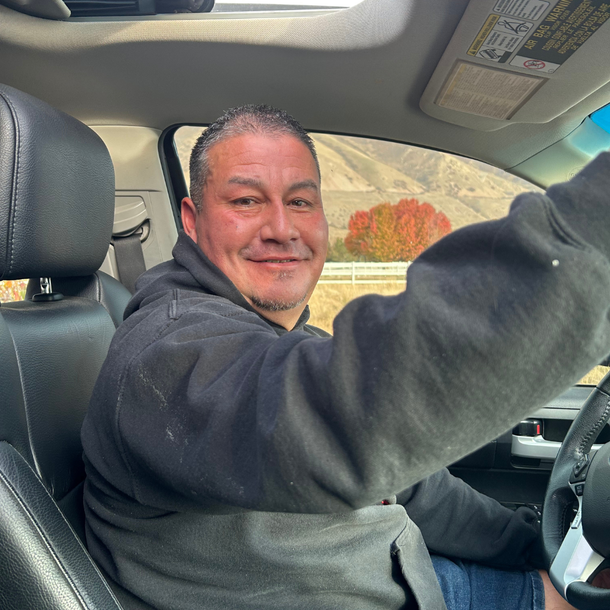 A man is sitting in the driver 's seat of a car.