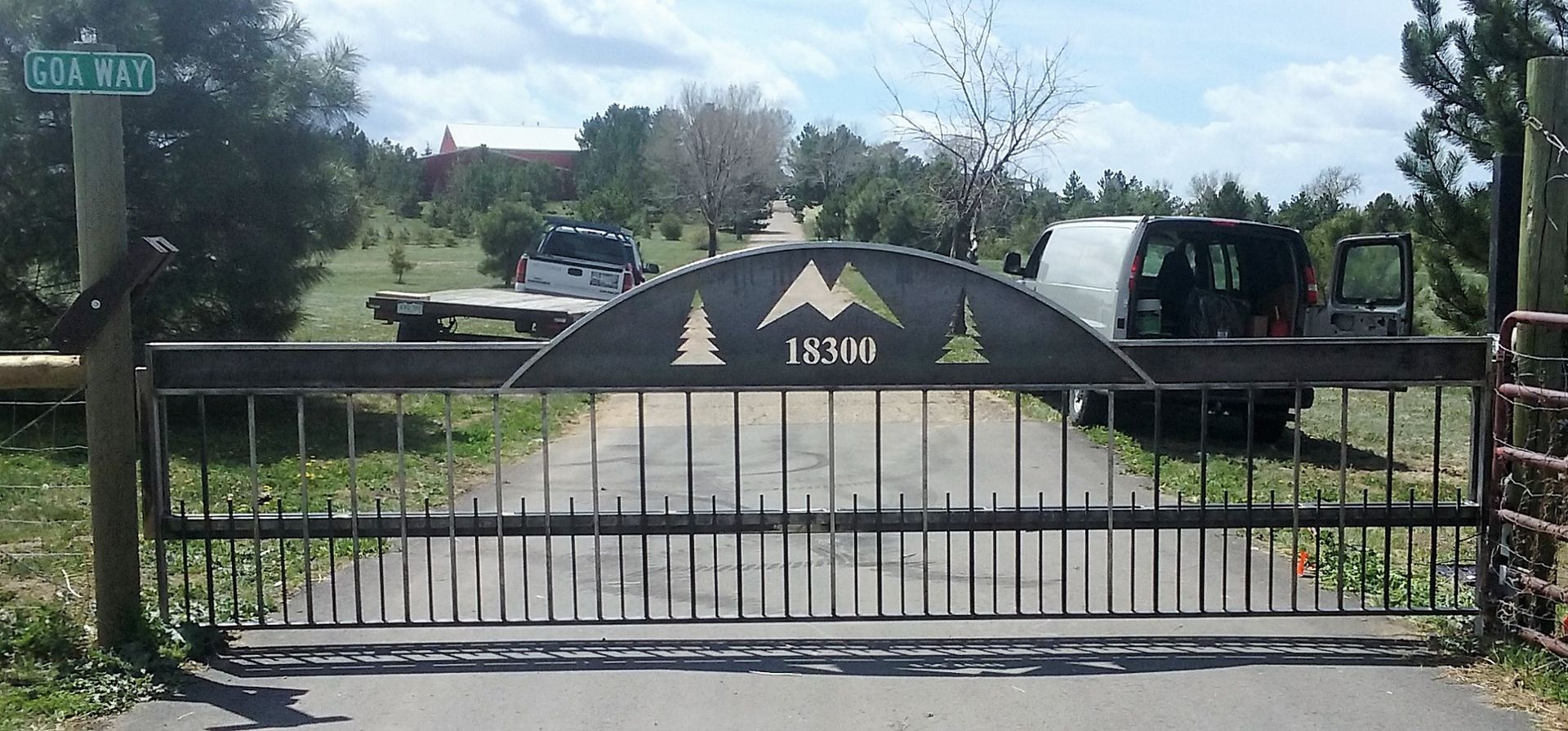 A sliding gate with a mountain and trees on it