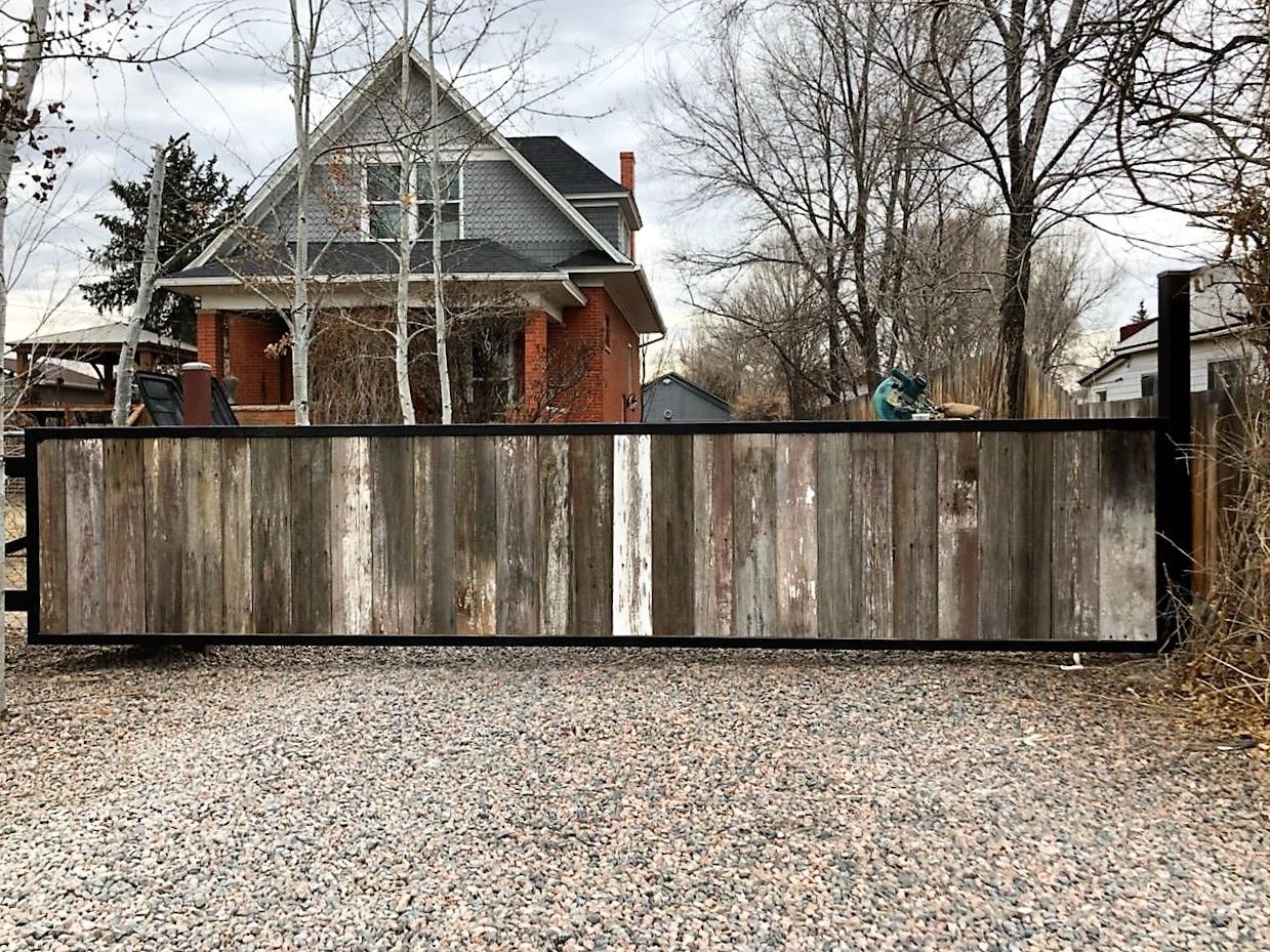 A wooden fence is sitting in front of a house.